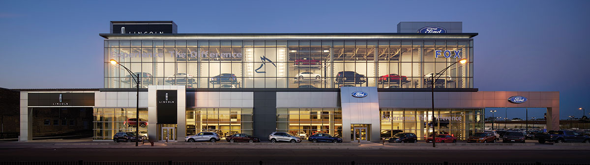 Subtle cove and slot fixtures illuminate exterior architectural forms without detracting from interior vehicle displays.